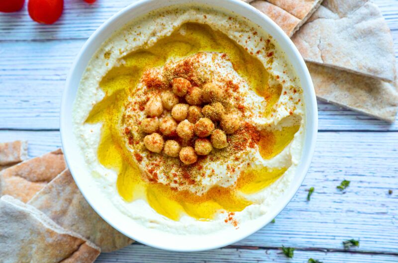 A bowl of hummus with cumin and paprika sprinkled on top