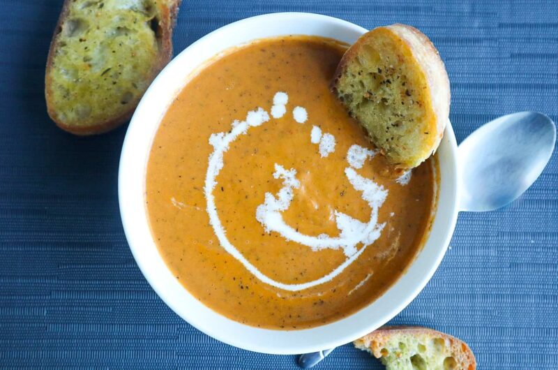 A bowl of Tomato Soup with toasted bread dipped in it
