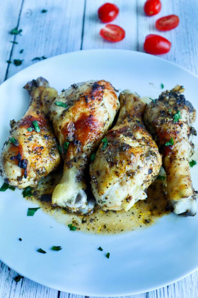 4 pieces of chicken drumsticks on a plate and parsley as a garnish 