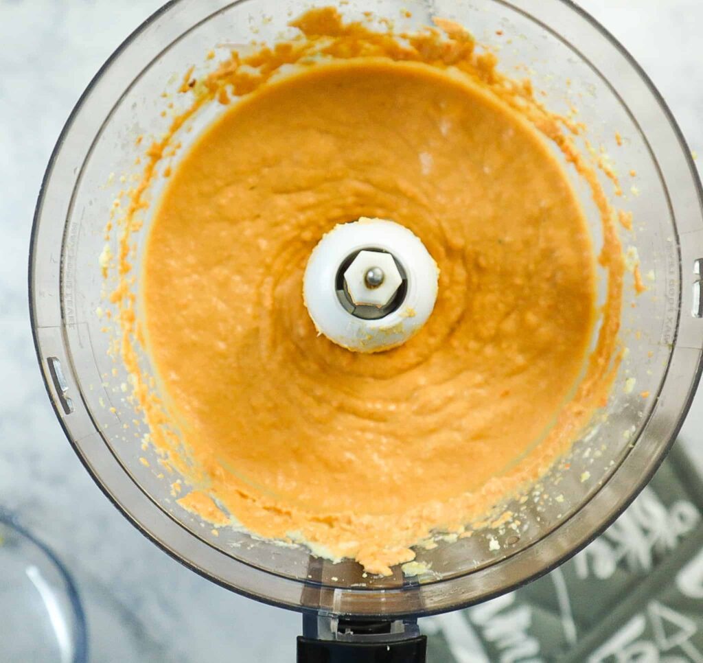 A food processor with the final result of the hummus. 