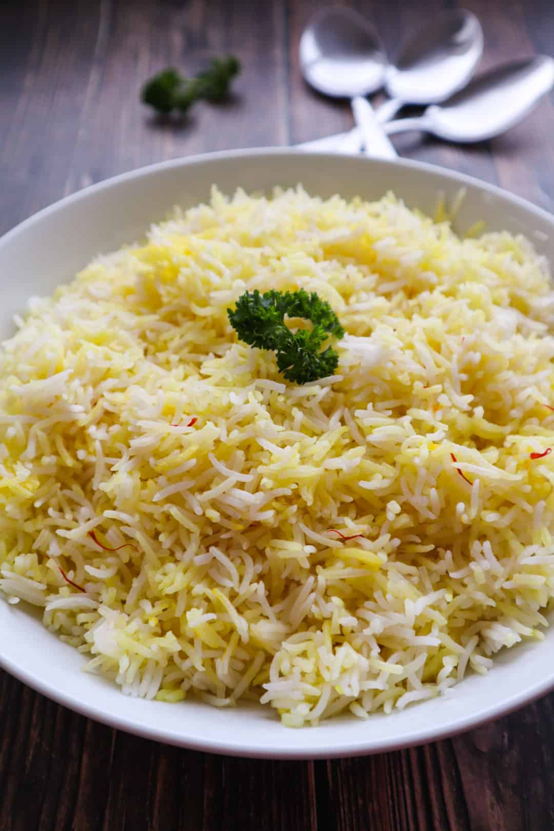A bowl of simple basmati rice with parsley as a garnish
