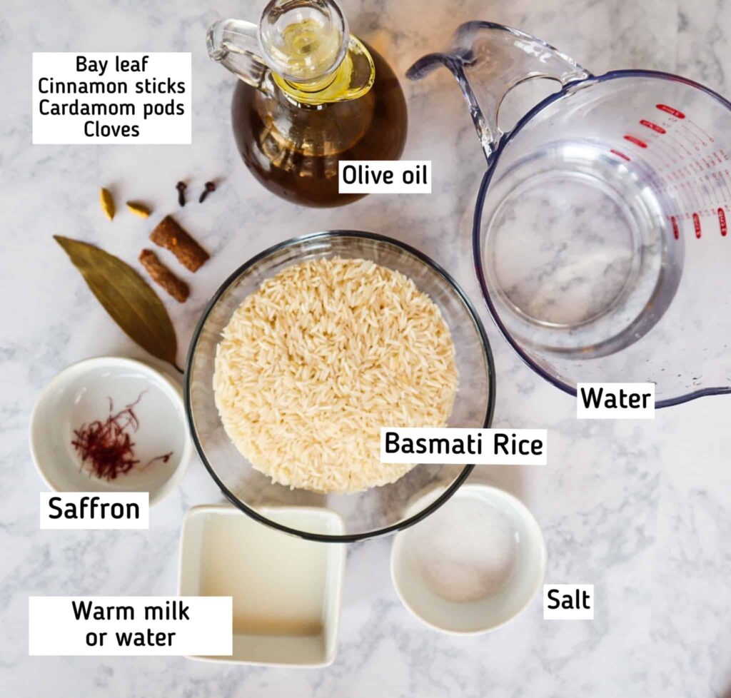 A bowl of basmati rice, salt, milk, saffron, bay leaf, cardamom pods, cloves, cinnamon sticks, water and olive oil 
