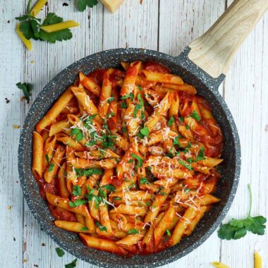A pan pf spicy penne arrabbiata with parmesan and parsley on top