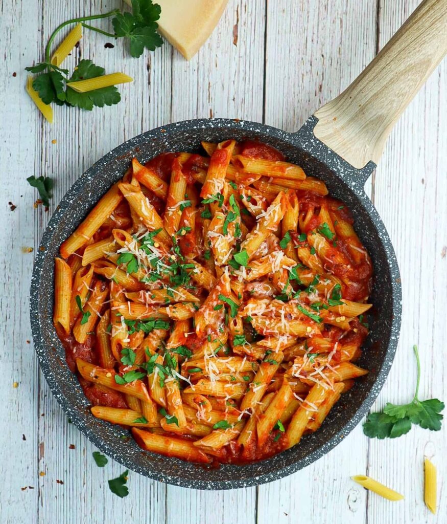A pan pf spicy penne arrabbiata with parmesan and parsley on top
