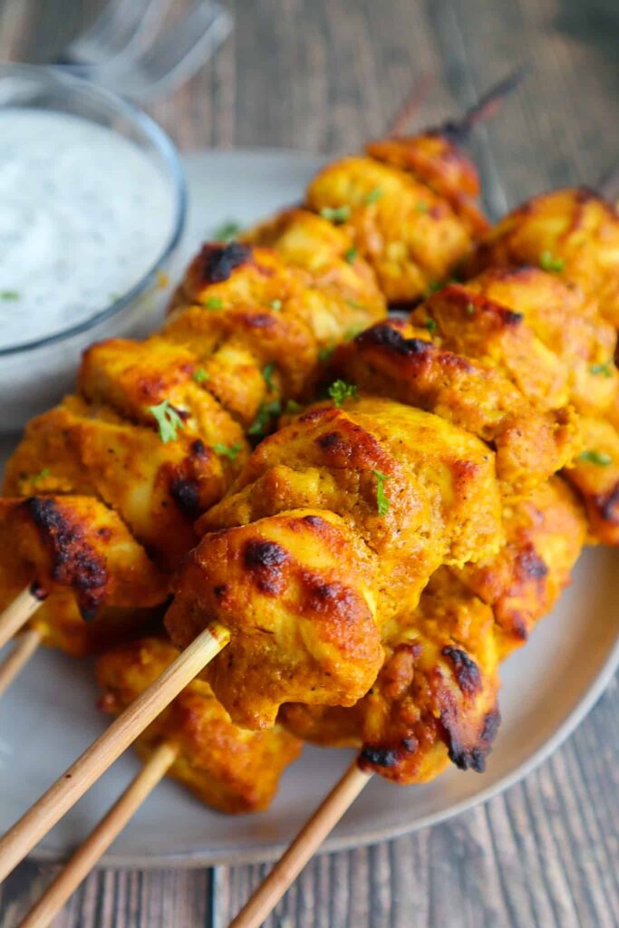A plate of tandoori skewers and a side of riata.