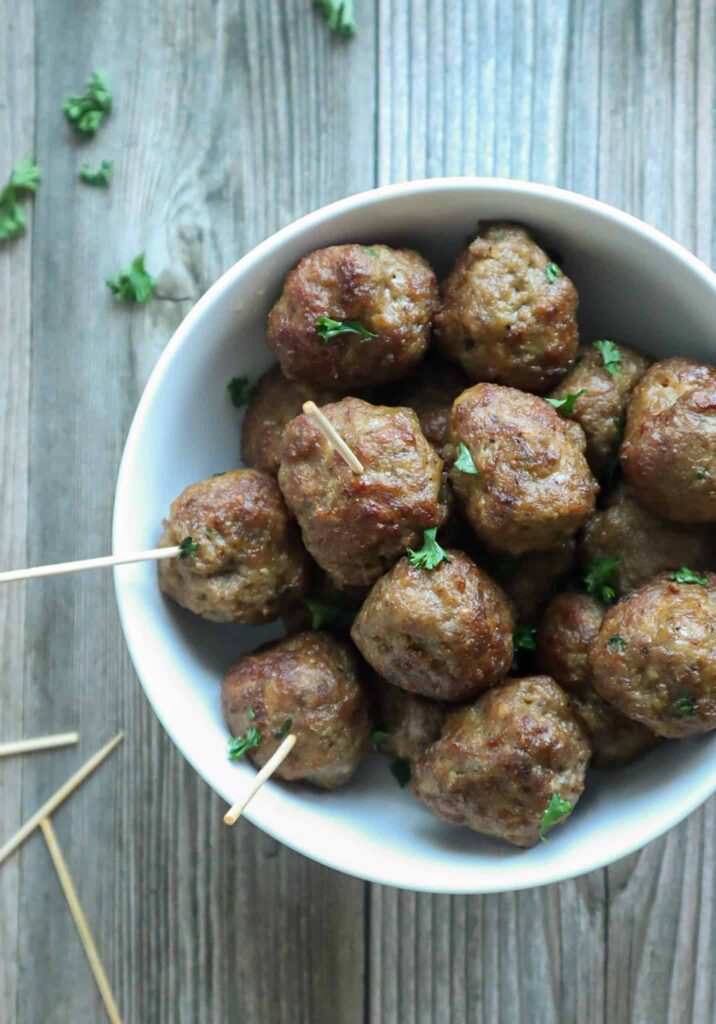 A bowl of air fryer meatballs with chopped parsley as garnish