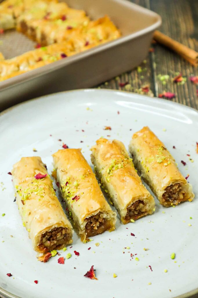 four pieces of baklava fingers on a plate 