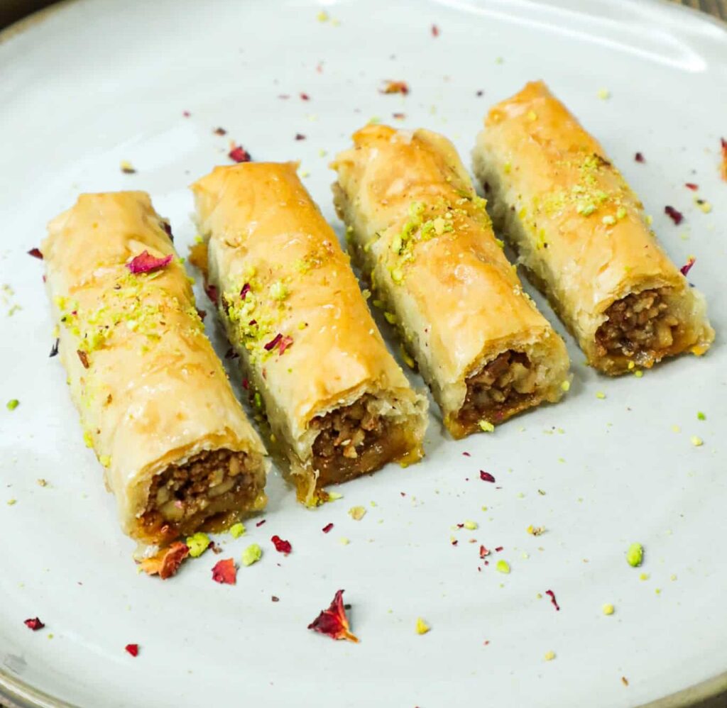 four pieces of baklava fingers on a plate