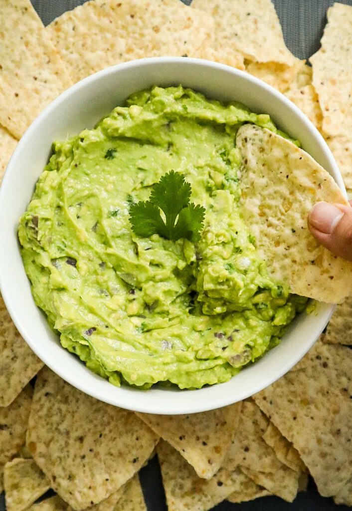 A bowl of Chipotle guacamole with tortilla chips