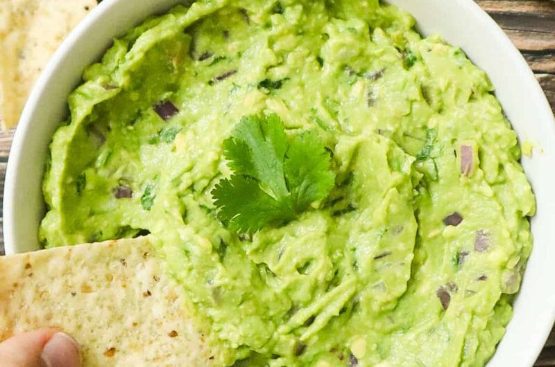 A bowl of guac with tortilla chips