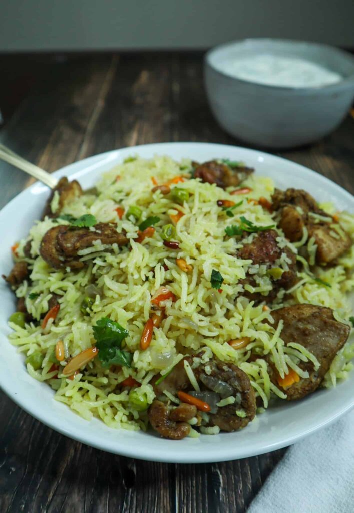 A dish of middle eastern rice with taziki sauce on the side