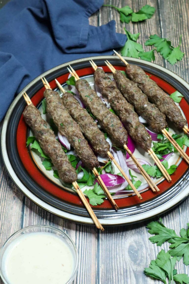 Kofta skewers on a bed of parsley and onions