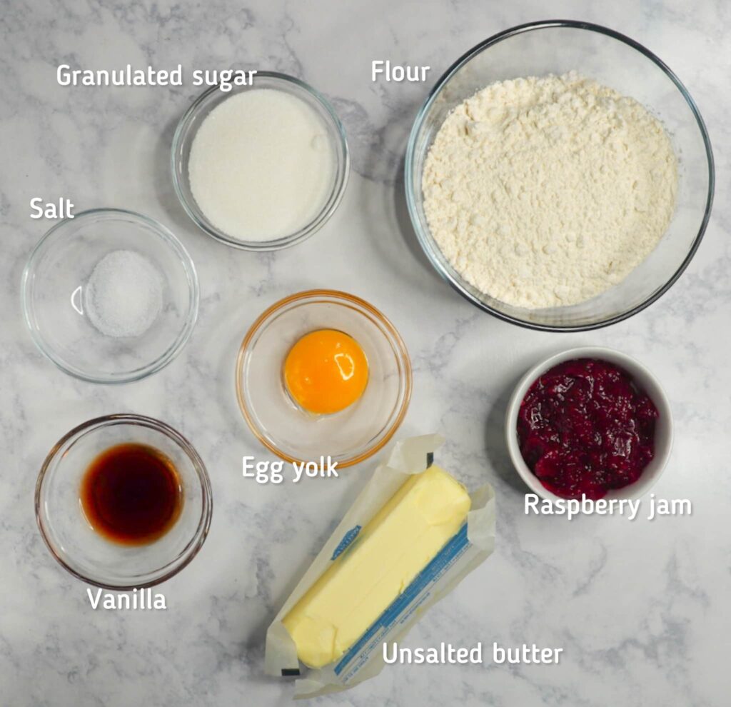 A bowl of flour, sugar, jam, egg, vanilla, salt and butter